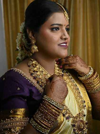 A three-quarter view of the bride. Her happy expression and elegant posture show how confident she feels in her complete Muhurtham look.