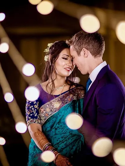 A beautiful color portrait of a couple surrounded by warm bokeh lights. The soft, out-of-focus lights create a magical and intimate atmosphere for this romantic shot.