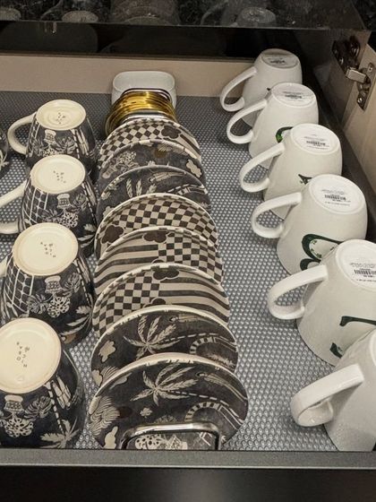 A close-up of a drawer organized with designer tea cups and saucers. Even delicate items can be safely stored in a drawer with the right system.