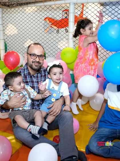 Look at these happy faces. A dad enjoys quality time with his little ones in our colorful ball pit, surrounded by balloons. It's all about creating these joyful family moments in a safe and fun environment.