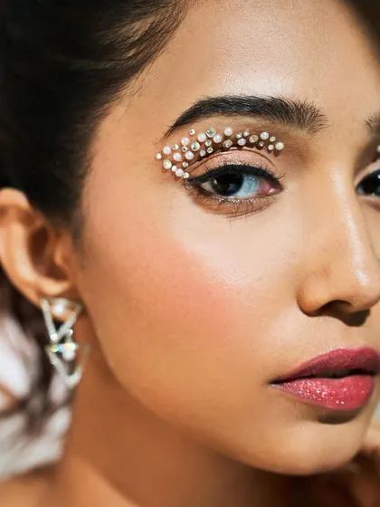 A close-up of the crystal eye makeup. Paired with clean skin and a soft pink lip, the eyes become a stunning piece of art.