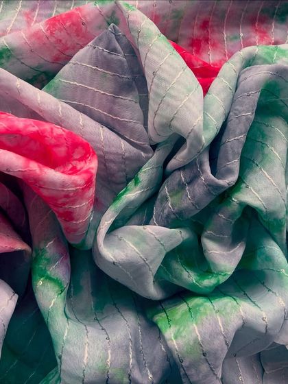 A stunning tie-dye tabby silk with a mix of pink and green hues. The subtle silver stripes add a touch of glamour, making it perfect for a festive saree or anarkali.