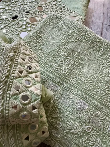 A close-up of the dupatta's corner, showing the intricate mirrorwork.