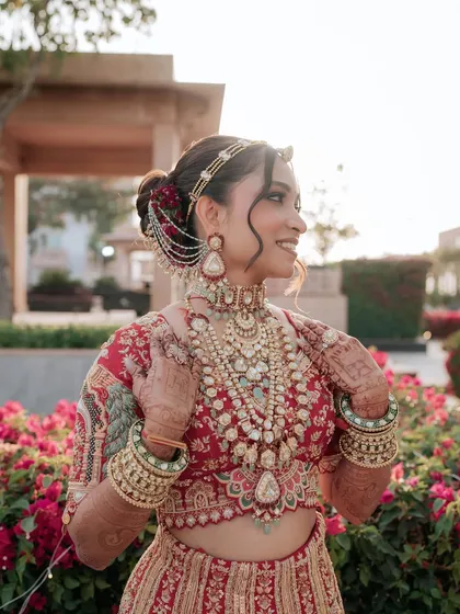Another stunning shot of the bride in her red lehenga. The makeup is soft and romantic, with a beautiful glow that catches the light perfectly.