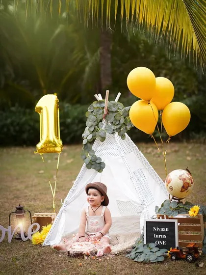 An adventurous first birthday celebrated outdoors. This little explorer enjoys his teepee setup in a beautiful park, a perfect theme for a candid and natural toddler photoshoot.