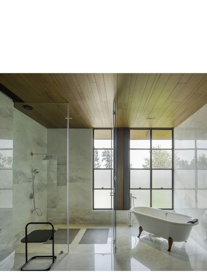 A bathroom in the Lakeshore house, where Indian marble and a wood-clad ceiling meet a large window. Even private spaces are designed to connect with the light and views outside.