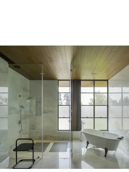 A bathroom in the Lakeshore house, where Indian marble and a wood-clad ceiling meet a large window. Even private spaces are designed to connect with the light and views outside.