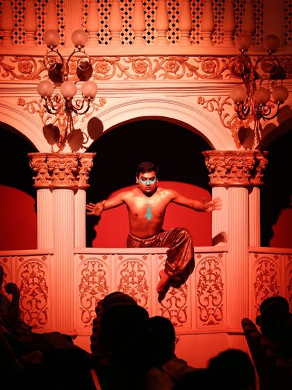 A character makes a dramatic entrance from the balcony boxes of the Royal Opera House in Mumbai. This moment broke the fourth wall, bringing the performance directly to the audience.