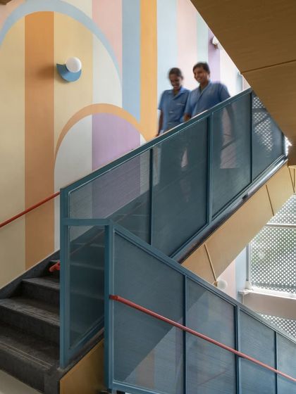 The staff members, or 'Akkas', are the soul of the school. Here they are seen on the colorful stairwell, a space designed to be as cheerful and uplifting as the people who use it every day.