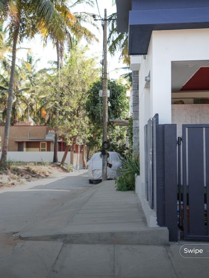 The simple and clean entrance gate and boundary wall of the Shashidhar Residence, reflecting the minimalist aesthetic of the home.