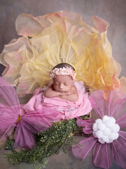 A fantasy flower setup. The oversized, whimsical flowers made of fabric and tulle create a magical, larger-than-life garden for this tiny sleeping beauty.