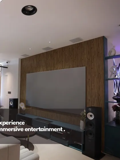 We believe world-class entertainment should blend perfectly with your home's design. This living room setup features a large format screen and high-fidelity tower speakers, creating a powerful media experience that complements the modern interior.
