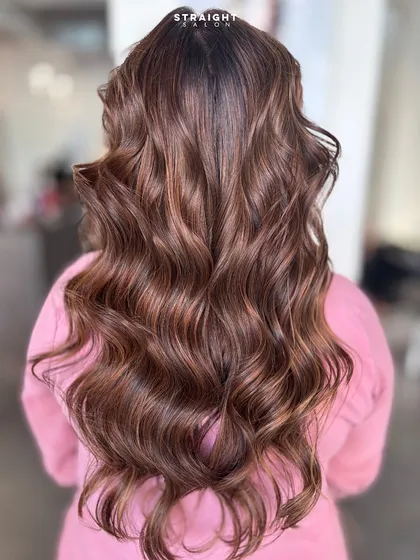 A perfect example of my signature balayage work. I hand-painted these highlights to create a seamless blend of rich brunette and caramel tones, finished with soft, voluminous waves.