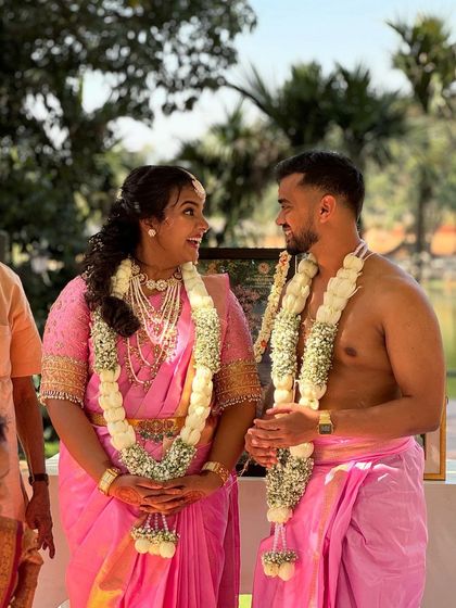 The couple shares a sweet moment during their engagement ceremony, adorned with simple yet elegant jasmine garlands.