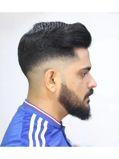 A clean high fade pompadour paired with a sharp beard shape. I focus on creating balanced, classic styles that are tailored to your look, ensuring the lines are perfect and the fade is seamless.