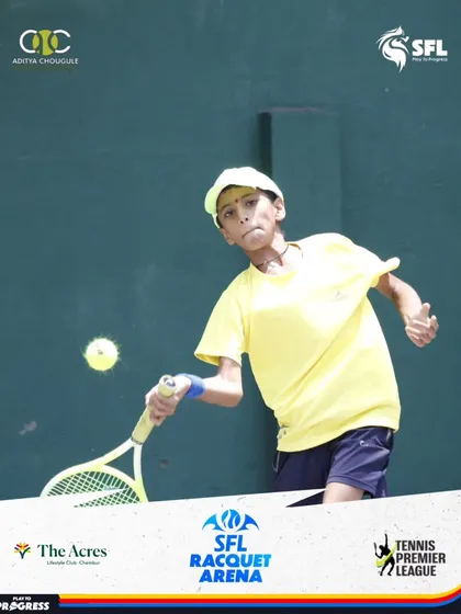 A young boy in a yellow shirt connects with a forehand, his form showing a solid foundation in tennis fundamentals.