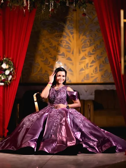 A regal portrait of a bride-to-be at her engagement. She is seated, allowing her magnificent purple ball gown to spread around her, creating a look of pure elegance and grandeur.