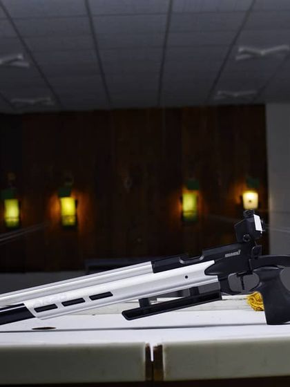 A Hammerli AR20 air rifle resting on the shooting bench, ready for a training session. The sleek design is optimized for balance and precision in 10m events.