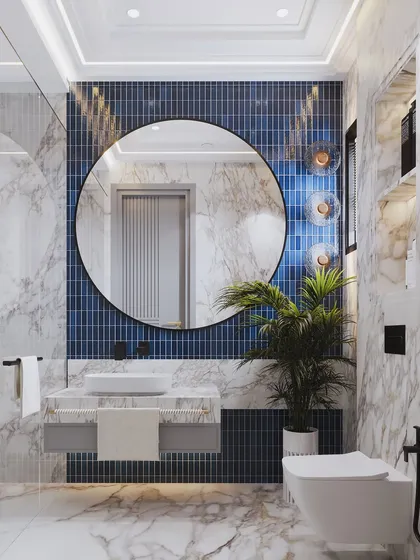 Another angle of the blue-tiled bathroom, showing the floating vanity and the warm glow of the globe-like wall sconces.