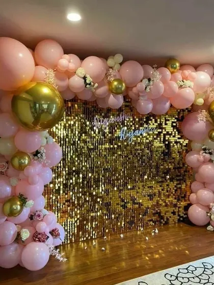 This setup shows how a sequin wall can be customized for your event. Here, a gold sequin backdrop is paired with a soft pink and gold balloon garland. I also arranged for a custom neon sign with the couple's names, making it a unique decoration for their engagement party.