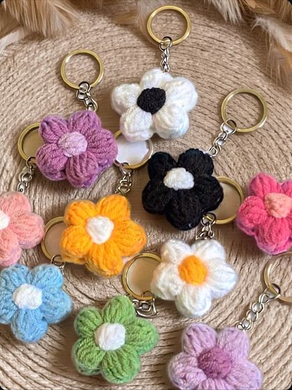 A collection of colorful crochet flower keychains. These cute, handmade accessories are perfect as party favors, small gifts, or a cheerful addition to your keys.