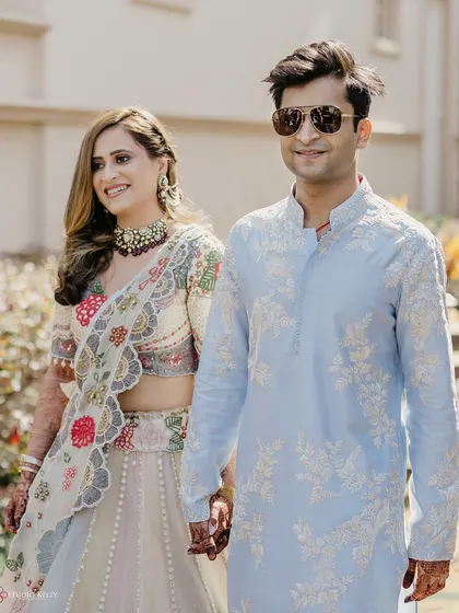 A candid shot of the couple walking together, the groom looking cool in his sunglasses.