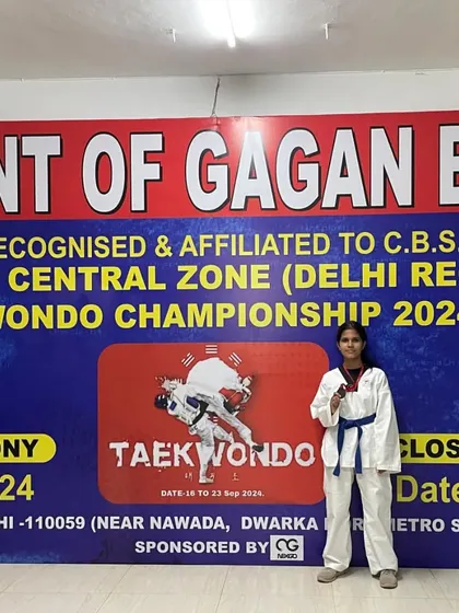 Anushka Sharma posing with her bronze medal in front of the official championship banner. A proud moment for her and the academy.
