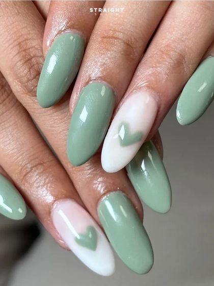 A close-up of the negative space heart, painted in the same sage green as the other nails for a cohesive look.