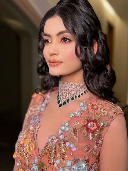 A close-up on the bride's soft makeup and the diamond and emerald choker.