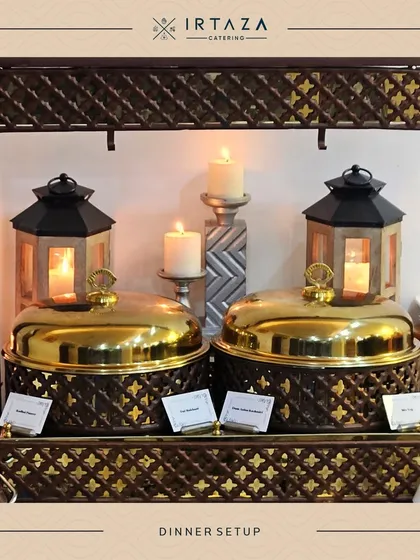 A classic dinner setup with two golden chafing dishes framed by candle-lit lanterns. This timeless arrangement is perfect for formal dinners and traditional celebrations.