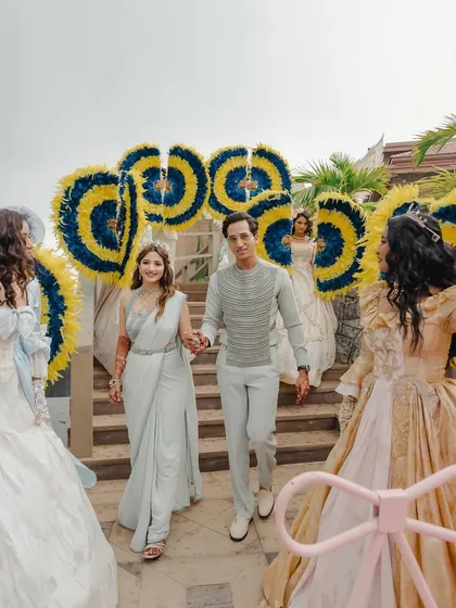 A grand entrance, with performers in elaborate costumes creating a path for the couple.