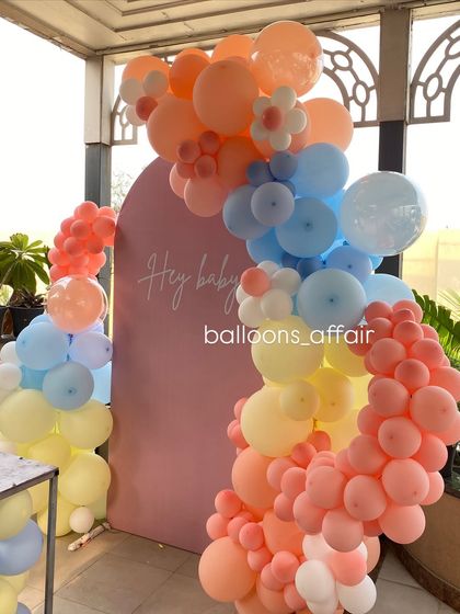 A detailed shot of the multi-colored pastel balloon arch, showcasing the intricate arrangement and daisy balloon accents.