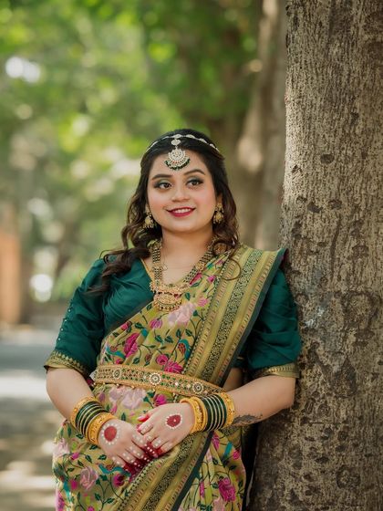 A lovely portrait of the bride leaning against a tree. Her confident smile and beautiful traditional attire make for a stunning solo shot from the engagement session.