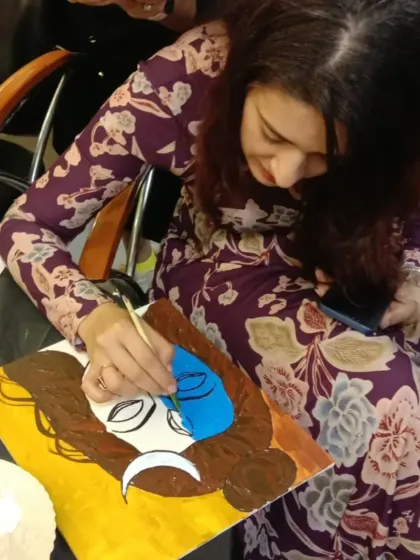 A student completely focused as she adds color to her painting of Lord Shiva. The act of painting a divine form can be a very calming and centering experience, allowing the artist to connect with her inner self.