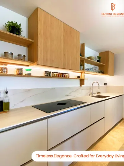 A minimalist kitchen design featuring light wood upper cabinets and open shelving, paired with sleek white base units and a marble-patterned backsplash.