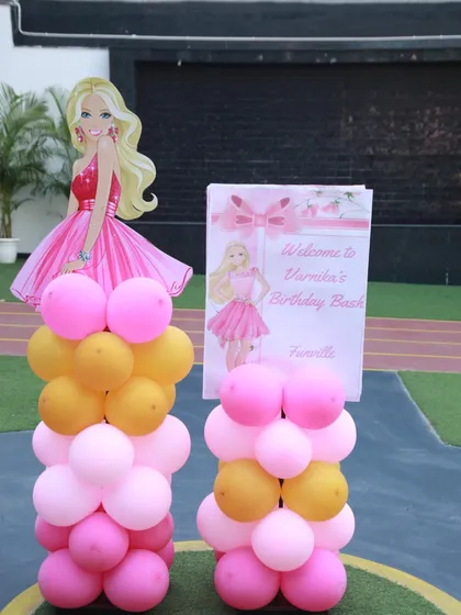Welcome to Barbie's Dreamhouse! This welcome sign for Varnika's birthday bash features a Barbie cutout and pillars of pink and gold balloons, setting a glamorous tone.