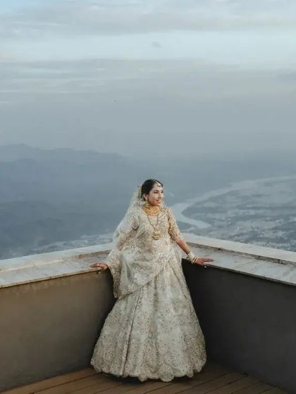 Another perspective of the bride against the epic mountain and river view. This full length shot emphasizes her magnificent gown and the grandeur of the destination.