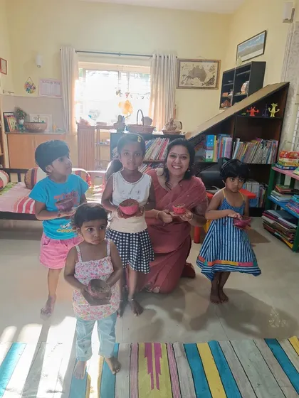 The storyteller joins the children for a photo, celebrating their wonderful creations.