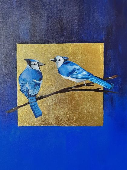 A finished canvas of two blue jays perched on a branch against a gold leaf square. The deep, ombre blue background makes the birds and the gold pop, creating a rich and striking image.