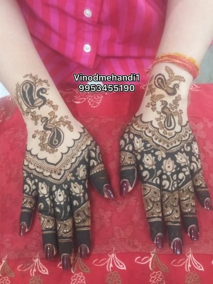 This design uses negative space to highlight the twin peacock motifs on the back of the hand. The dark, filled-in patterns on the palm and fingers create a beautiful contrast.