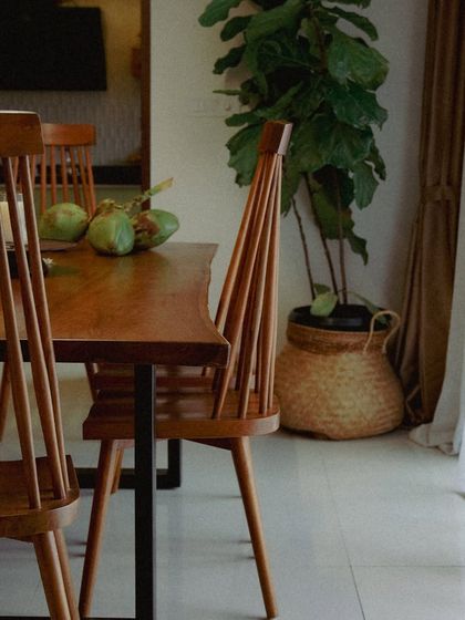 My 'Alto' dining chairs surrounding a live-edge teak table. The high, spindled backrest is inspired by classic Windsor chairs but with a modern, minimalist feel.