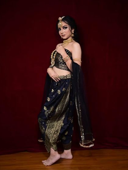For a bold and unconventional look, I offer this black and gold dhoti-style saree. It's a modern take on traditional wear, perfect for someone who wants to make a unique style statement.