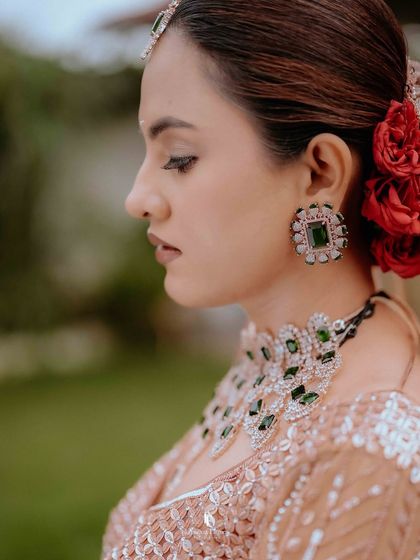 A detailed shot of the bride's jewelry and the beautiful red flowers in her hair.