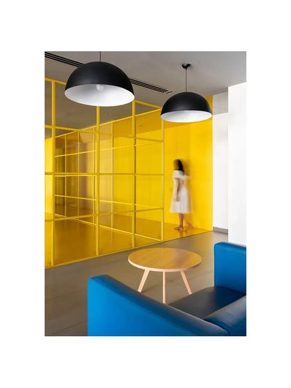 This lounge in 'The Amber Encase' combines a bright blue sofa with the signature yellow of the project, creating a vibrant and energetic social space.