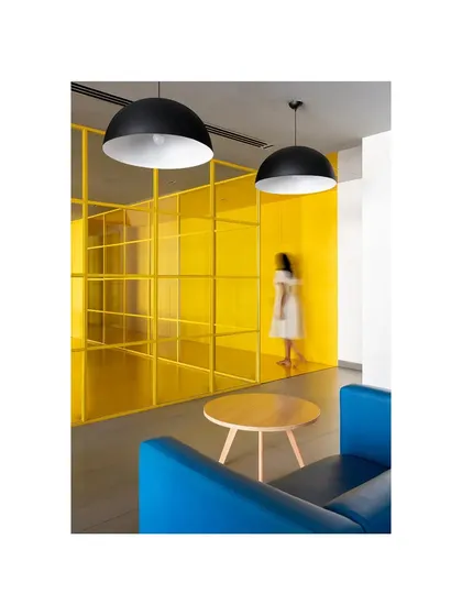 This lounge in 'The Amber Encase' combines a bright blue sofa with the signature yellow of the project, creating a vibrant and energetic social space.