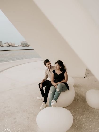 A candid, laughing moment between the couple, framed by modern architecture.
