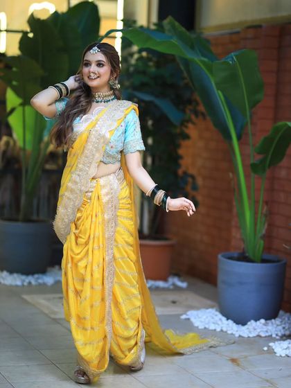 A full view of a bride in a stunning yellow Nauvari saree. I created a half up, half down hairstyle with soft waves, perfect for a modern yet traditional look.