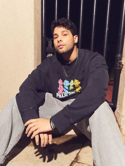 A close-up portrait from the Siddhant Chaturvedi HT Brunch shoot. This shot offers a more intimate feel, focusing on the graphic details of the sweatshirt and the simple chain accessory.