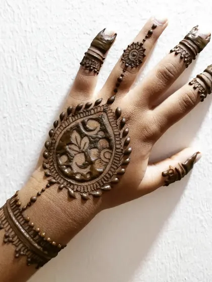 A more intricate design for a child, featuring a large central motif and detailed fingers.