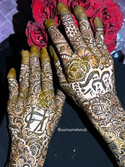 A stunning design featuring the initials 'H' and 'S' on separate hands, surrounded by intricate floral and leaf patterns.